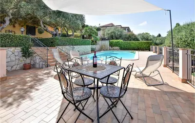 a patio with a table and chairs and a pool at Mages in Casteldaccia
