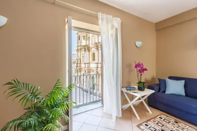 a living room with a blue couch and a balcony at Palazzo Edy&Stef 1 in Palermo