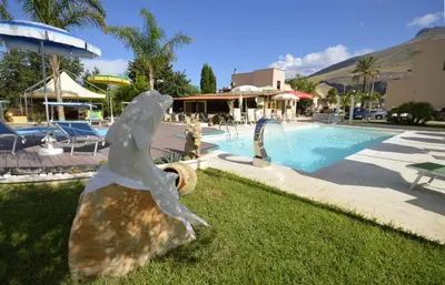 a statue of a bird standing next to a swimming pool at Hotel Oasi da Paolo in Castelluzzo