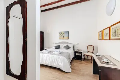 a bedroom with a bed and a table and a mirror at Giulio Cesare 14, Residence in Palermo