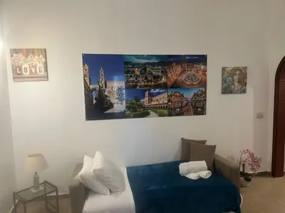 a bedroom with a bed with four pictures on the wall at La maison à la cathedral in Palermo