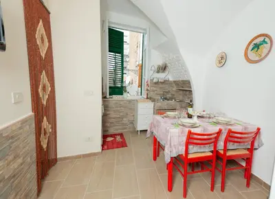 a dining room with a table and red chairs at La maison à la cathedral in Palermo