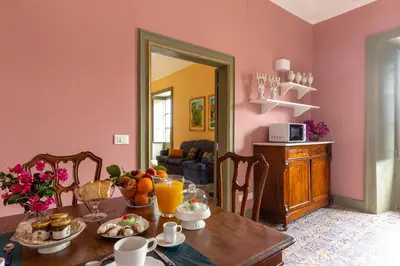 a dining room with a table with fruit on it at Ajutamicristo Domus by DomuSicily in Palermo