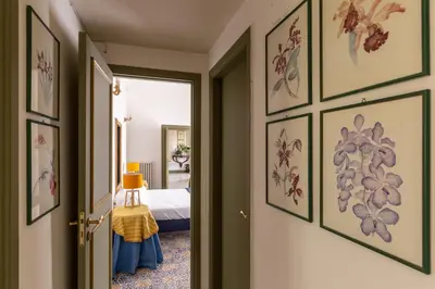 a hallway with a room with a bed and framed pictures at Ajutamicristo Domus by DomuSicily in Palermo