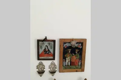 two framed pictures on a white wall with figurines at casa immersa nel verde al centro di Palermo in Palermo