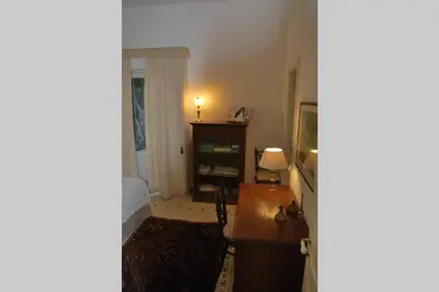 a living room with a desk and a lamp at casa immersa nel verde al centro di Palermo in Palermo