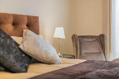 a bedroom with a bed and a chair and a lamp at Palazzo Ardizzone in Palermo