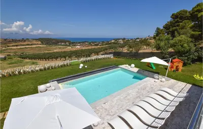 an outdoor swimming pool with chairs and umbrellas at Stunning Home In Balestrate in Balestrate