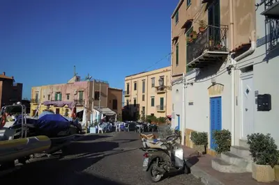 a motorcycle parked on a street next to buildings at Casa nel borgo marinaro di Santa Nicolicchia in Santa Flavia