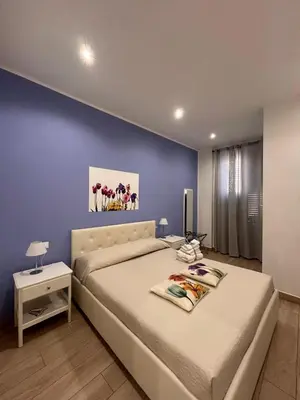 a bedroom with a bed and a blue wall at A Casa di Josephine in Palermo