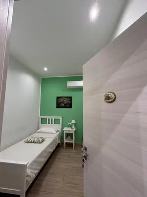 a bedroom with a bed and a green wall at A Casa di Josephine in Palermo