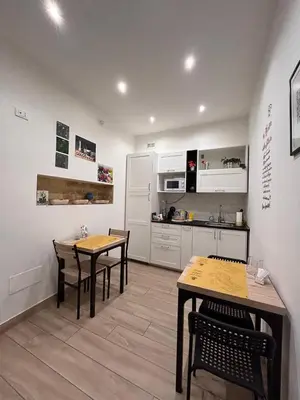 a kitchen with two tables and a white refrigerator at A Casa di Josephine in Palermo