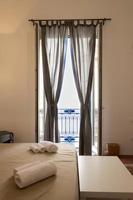 a bed with two towels on it in front of a window at Piazza Florio Rooms in Palermo