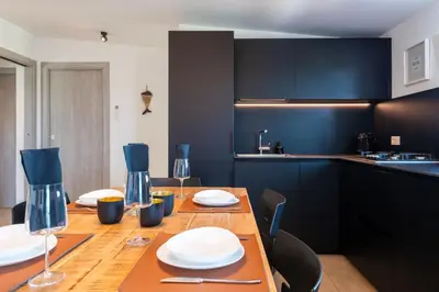a kitchen with a wooden table with plates and wine glasses at Villa Mendez in Castellammare del Golfo