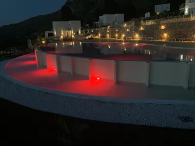 a swimming pool with red lights in the night at Villa Mendez in Castellammare del Golfo