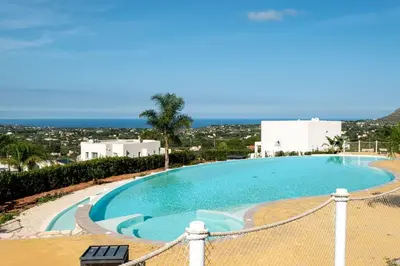 a large swimming pool with a view of the ocean at Villa Mendez in Castellammare del Golfo