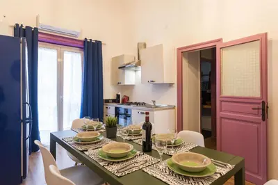 a kitchen with a table with a bottle of wine at Large apartment near Politeama 2 bathrooms Up to 8 Guests in Palermo