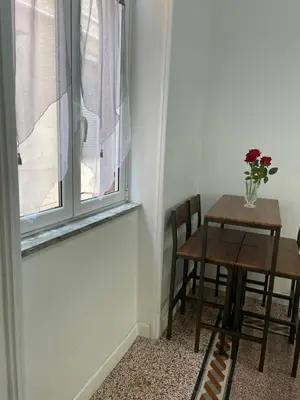 a table and chairs in a room with a window at Charmie flat in Palermo