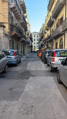 a street with cars parked on the sides of buildings at Dost in Palermo