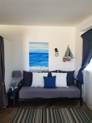 a living room with a couch with blue and white pillows at Kalimera in Capaci