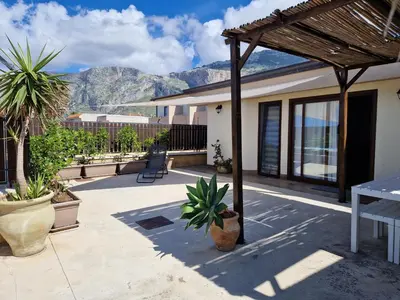 a patio with potted plants and a view of mountains at Kalimera in Capaci