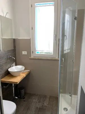 a bathroom with a sink and a glass shower at casa Cuffa in San Vito lo Capo