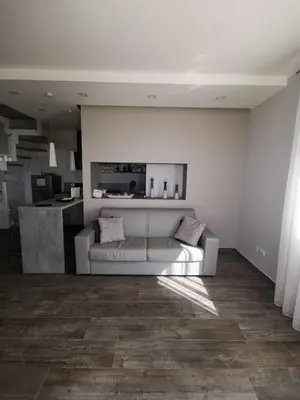 a living room with a white couch and a kitchen at casa Cuffa in San Vito lo Capo
