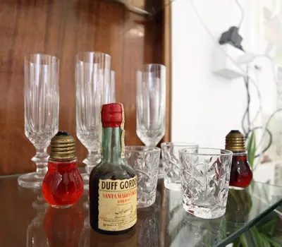 a glass table with glasses and a bottle of hot sauce at Alfredo Apartment a casa di alfredo in Palermo