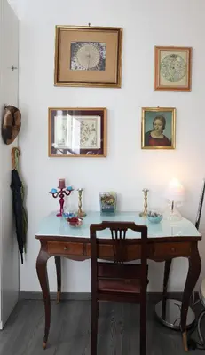 a desk in a room with a chair and pictures on the wall at Alfredo Apartment a casa di alfredo in Palermo