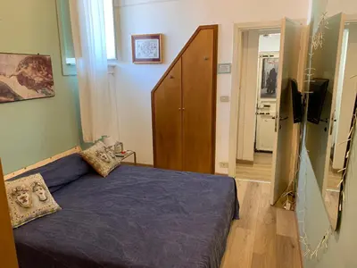 a bedroom with a bed with a blue comforter at Alfredo Apartment a casa di alfredo in Palermo