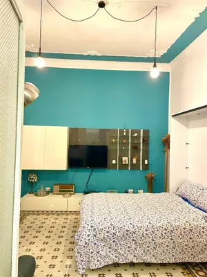 a bedroom with a blue wall and a bed at Funky flat in Palermo