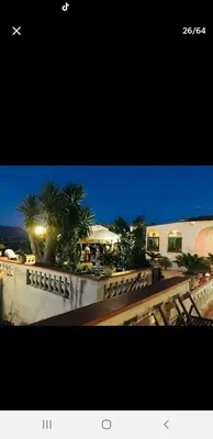 a view of a building with palm trees at night at Villa Teresa in Trappeto