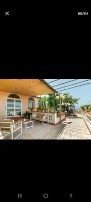 a picture of a building with tables and benches at Villa Teresa in Trappeto