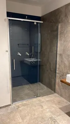 a glass shower door in a bathroom with a sink at Villa della Pigna in Scopello