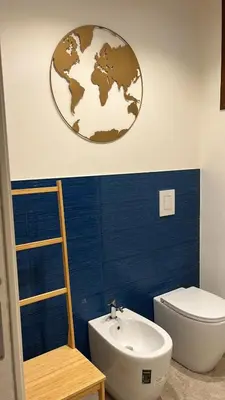 a bathroom with a toilet sink and a globe on the wall at Villa della Pigna in Scopello