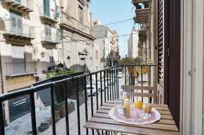 a table with a plate of food on a balcony at Casa Linda in Palermo