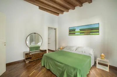 a bedroom with a green bed and a mirror at Casa Linda in Palermo