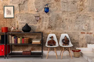 two white chairs sitting next to a book shelf at Valverde Art Space Loft by DomuSicily in Palermo