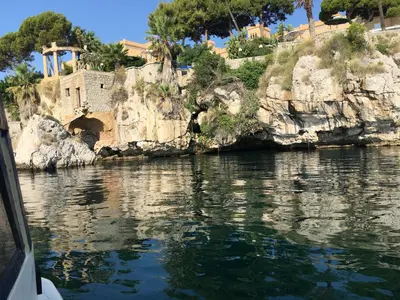 a body of water with a building on a cliff at Casa Igiea in Palermo