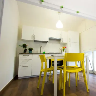 a kitchen with yellow chairs and a table at Casa MaMo 36 in Palermo