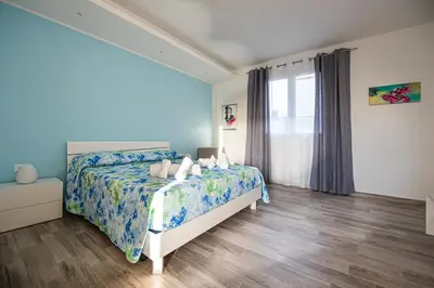 a bedroom with a bed and a window at L' Arcobaleno B&B in Castelluzzo
