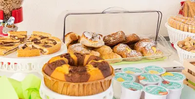 a table with a bunch of different types of pastries at L' Arcobaleno B&B in Castelluzzo