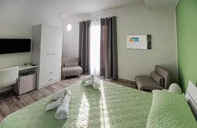 a bedroom with a bed and a living room at L' Arcobaleno B&B in Castelluzzo