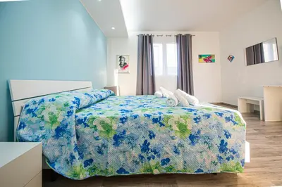 a bedroom with a bed with a blue comforter at L' Arcobaleno B&B in Castelluzzo