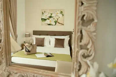 a reflection of a bedroom with a bed in a mirror at Porta Aragonese Luxury Rooms in Palermo