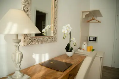 a dining room table with a lamp and a mirror at Porta Aragonese Luxury Rooms in Palermo