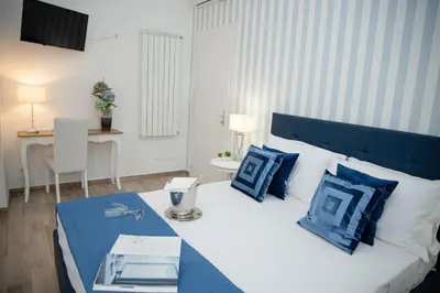 a bedroom with a large bed with blue pillows at Porta Aragonese Luxury Rooms in Palermo