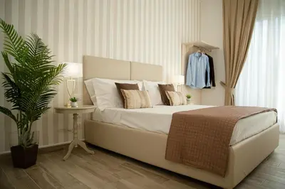 a bedroom with a white bed and a plant at Porta Aragonese Luxury Rooms in Palermo