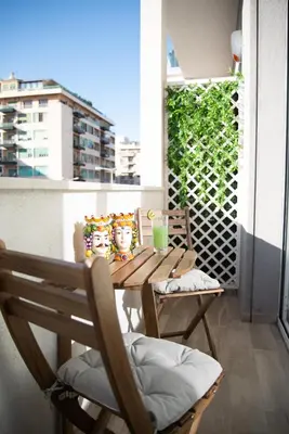 a wooden table on a balcony with drinks on it at Porta Aragonese Luxury Rooms in Palermo