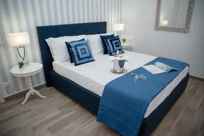 a bedroom with a large bed with blue and white pillows at Porta Aragonese Luxury Rooms in Palermo
